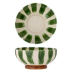 Ceramic bowl with green and white striped design on a white background