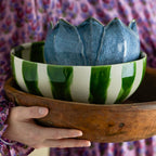 Person holding a large ceramic bowl with a unique design