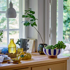 Decorative table setting with vases, bowls, and plants in a bright room.