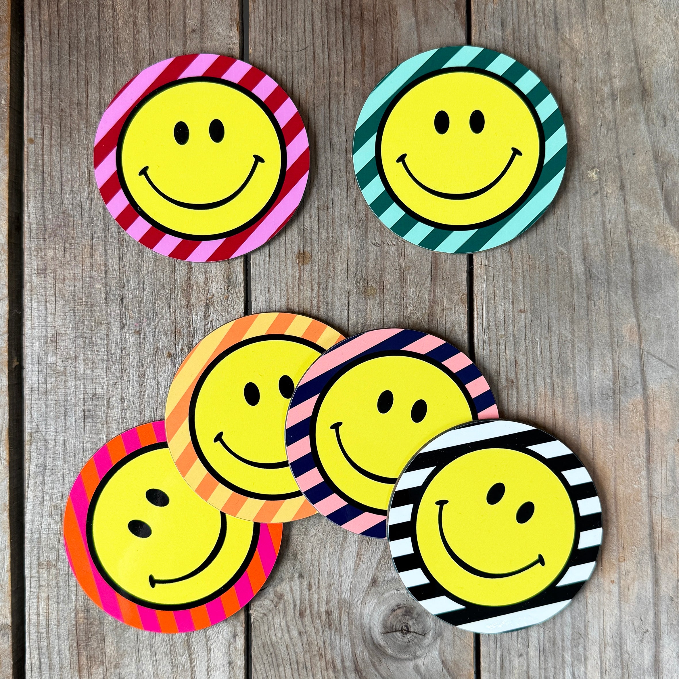 Smiley Coasters on a Striped background. Designed by Love Frankie