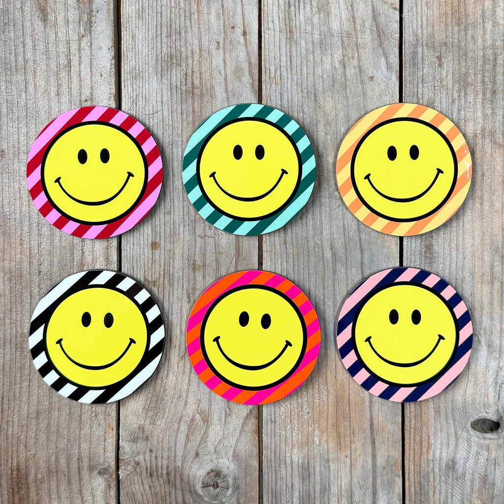 Smiley Coasters on a Striped background. Designed by Love Frankie