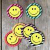 Smiley Coasters on a Striped background. Designed by Love Frankie
