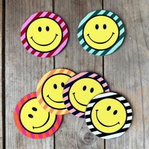 Smiley Coasters on a Striped background. Designed by Love Frankie